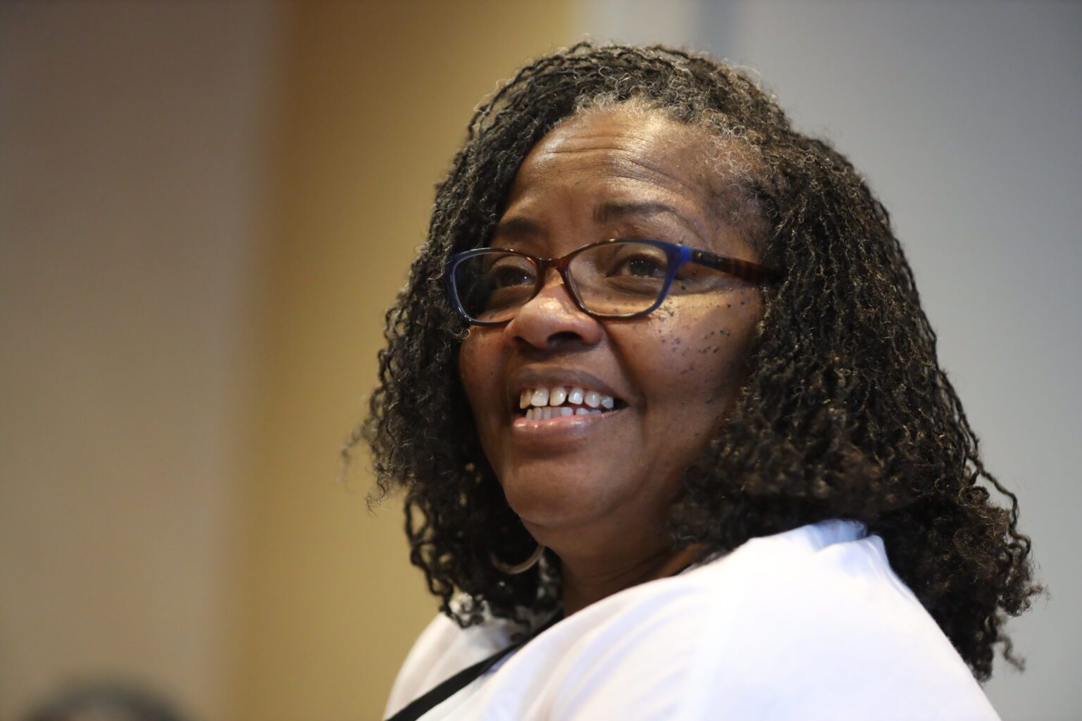 Woman wearing glasses, smiling warmly
