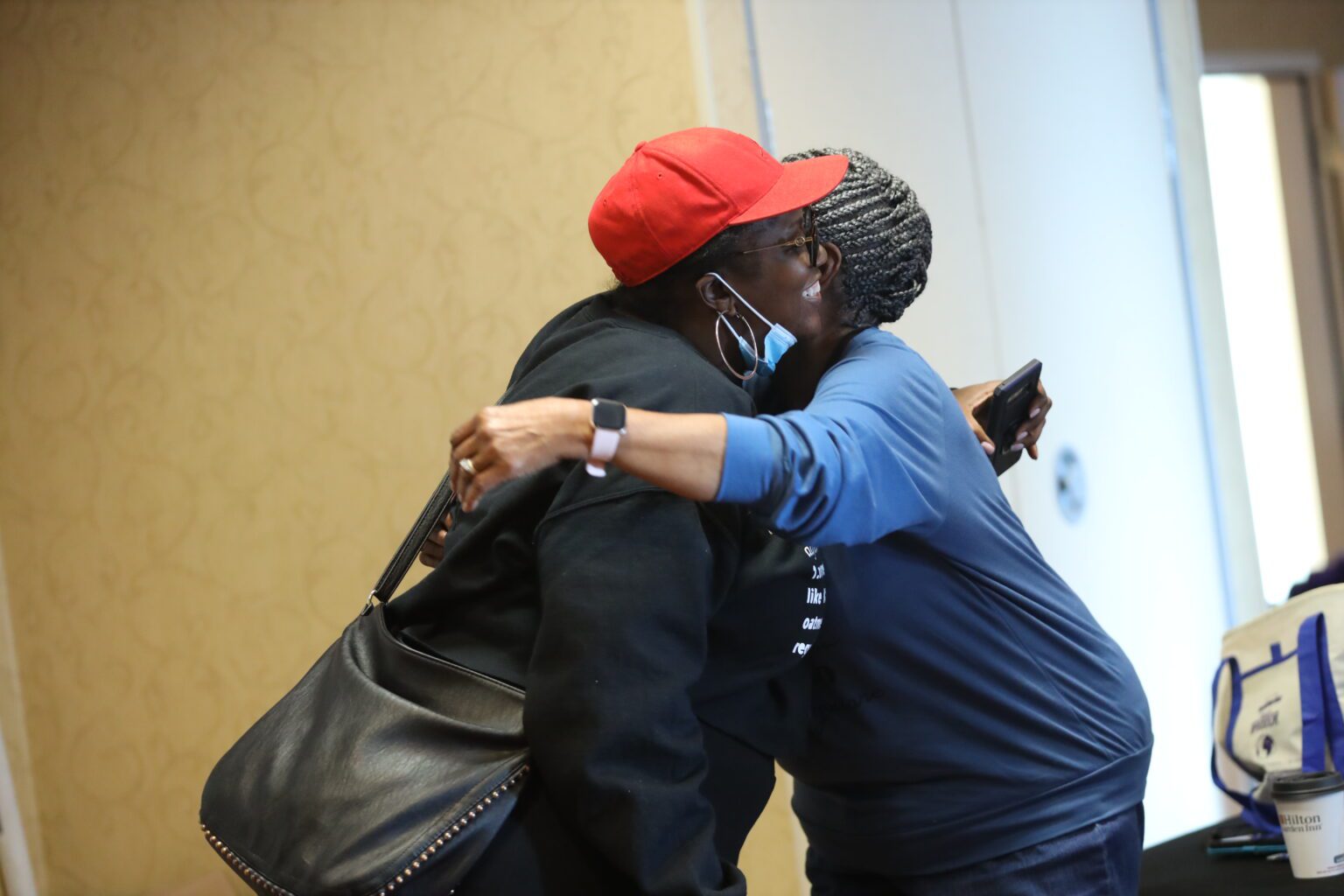 Joyful hug between two individuals indoors
