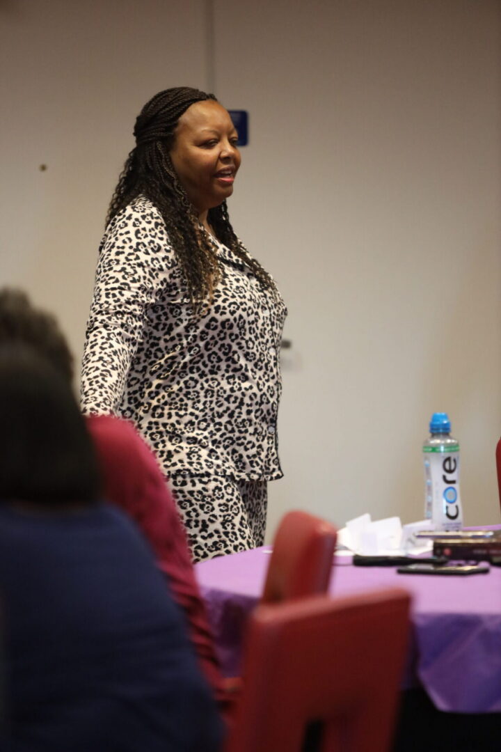 Speaker standing beside a table