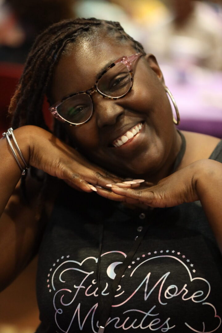 Smiling woman posing with hands under chin